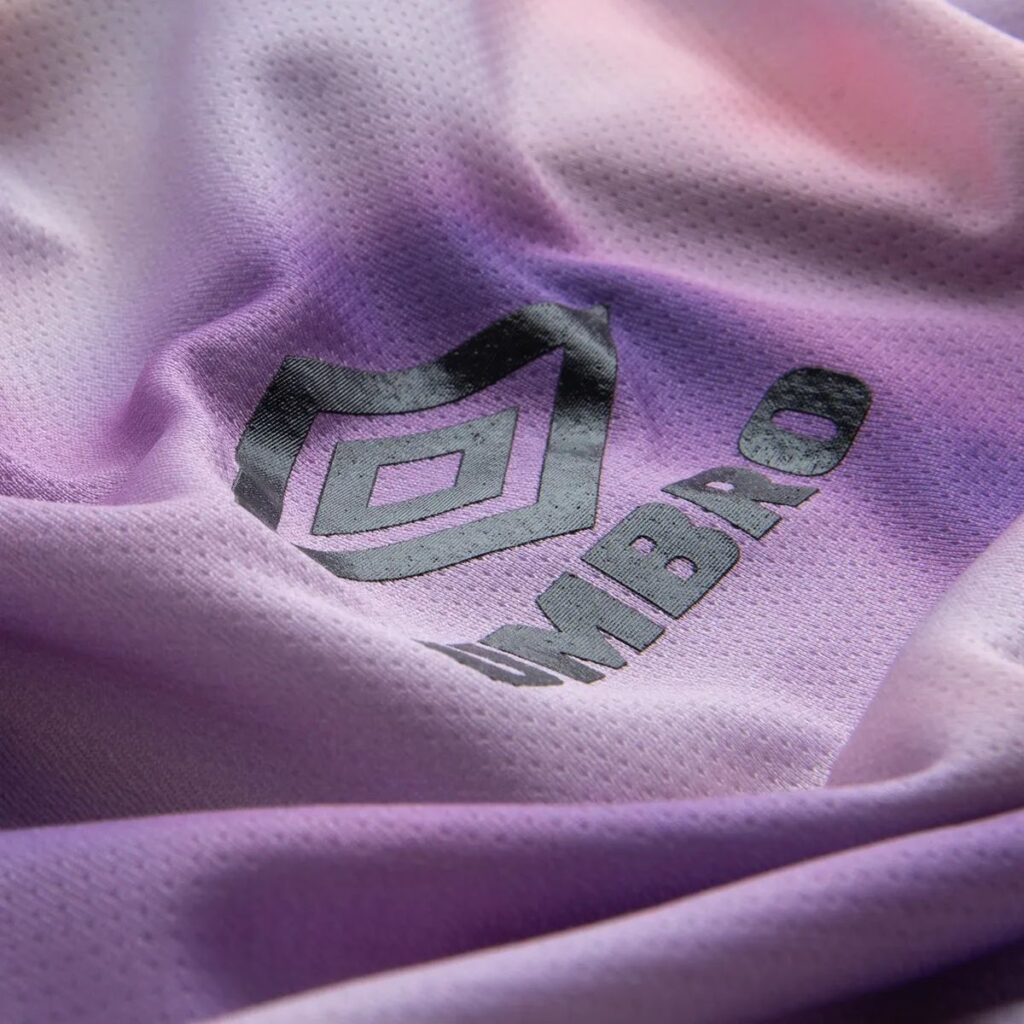 A Camisa Umbro Jersey "Urban Glow" é a fusão perfeita entre estilo e desempenho. Inspirada nas vibrantes paisagens urbanas, esta peça traz um design moderno e arrojado que vai iluminar seu visual dentro e fora dos campos. Confeccionada com tecido de alta tecnologia, proporciona um ajuste confortável e liberdade de movimento, ideal para qualquer atividade esportiva.