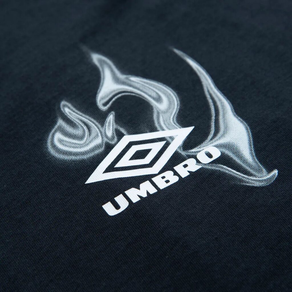 Mergulhe na vibração vibrante da cidade com a camiseta Umbro oversized da coleção Urban Glow. Esta peça é um tributo à energia e ao dinamismo dos jovens urbanos, capturando a essência das noites iluminadas por neon e a autenticidade de viver intensamente.