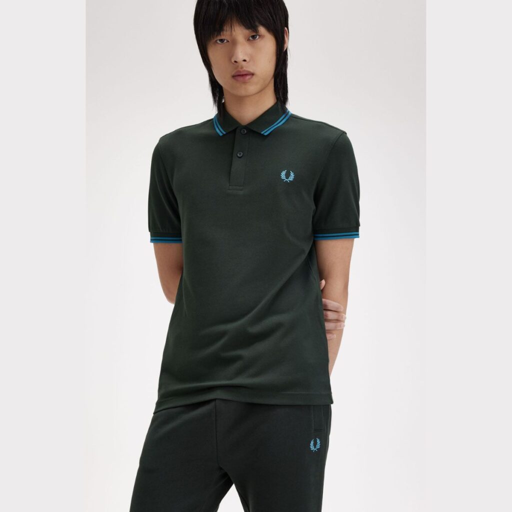 A Camiseta Polo Fred Perry Twin Tipped é uma peça icônica da marca, conhecida por seu design clássico e atemporal. Confeccionada em piqué de algodão premium, essa polo oferece conforto, durabilidade e um estilo sofisticado.