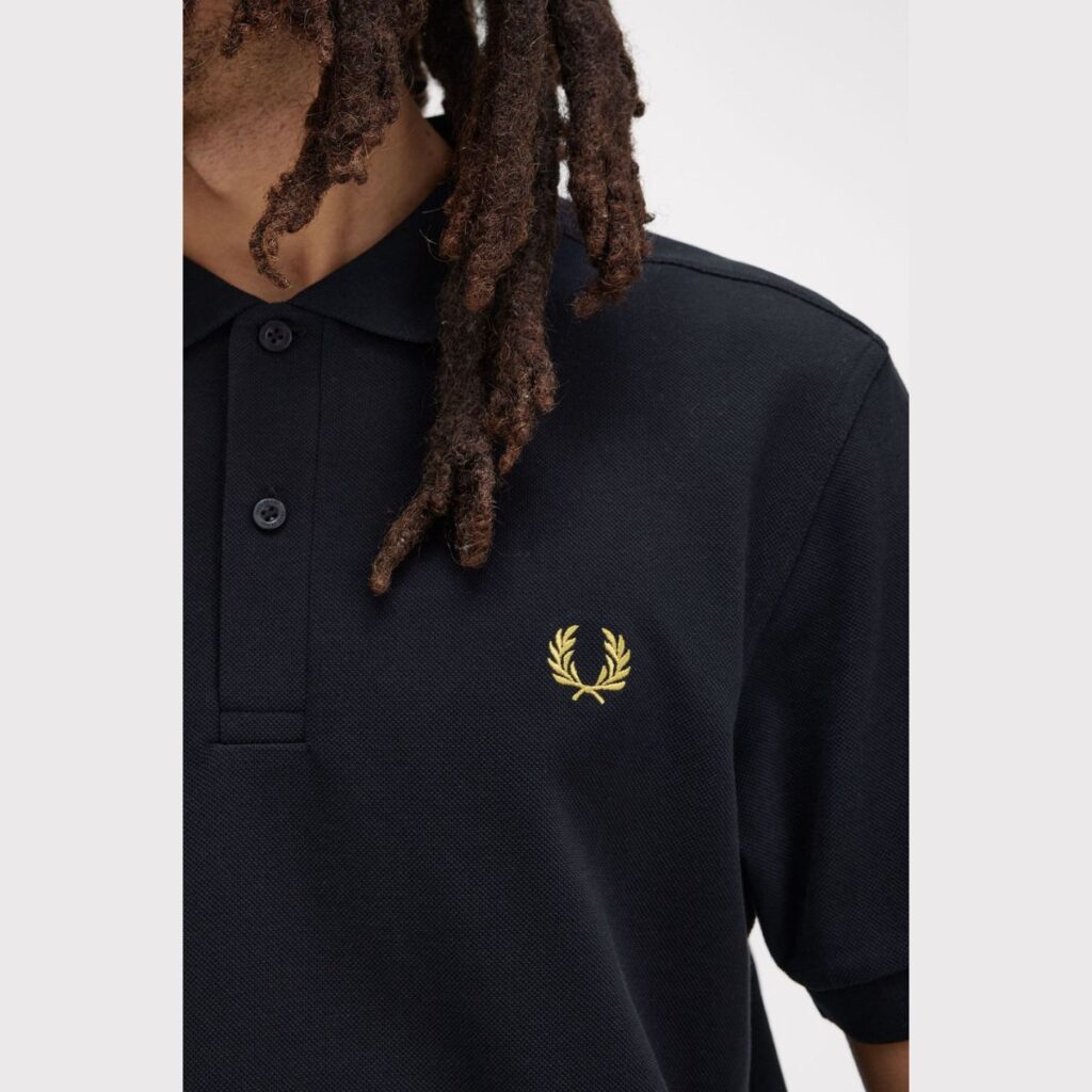 A Camiseta Polo Fred Perry M6000 é uma peça icônica da marca, conhecida por seu design clássico e atemporal. Confeccionada em piqué de algodão premium, essa polo oferece conforto, durabilidade e um estilo sofisticado.