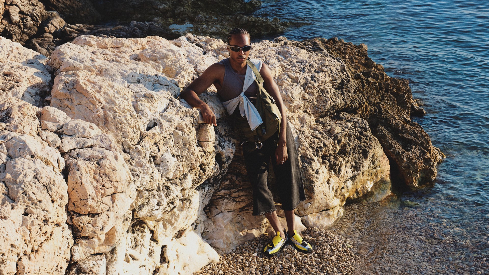 Pessoa Em Cenário Costeiro Rochoso Usando O Adidas Virginia Watermoc Amarelo, Em Imagem Da Campanha De Pharrell Williams