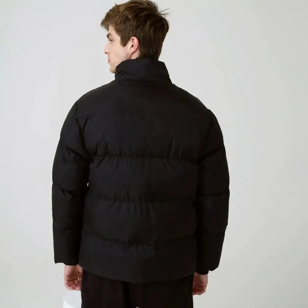 A Jaqueta Masculina Fila Round é a escolha ideal para os dias mais frios. Confeccionada em matelassê de poliéster com modelagem puffer, oferece isolamento térmico e conforto inigualável.