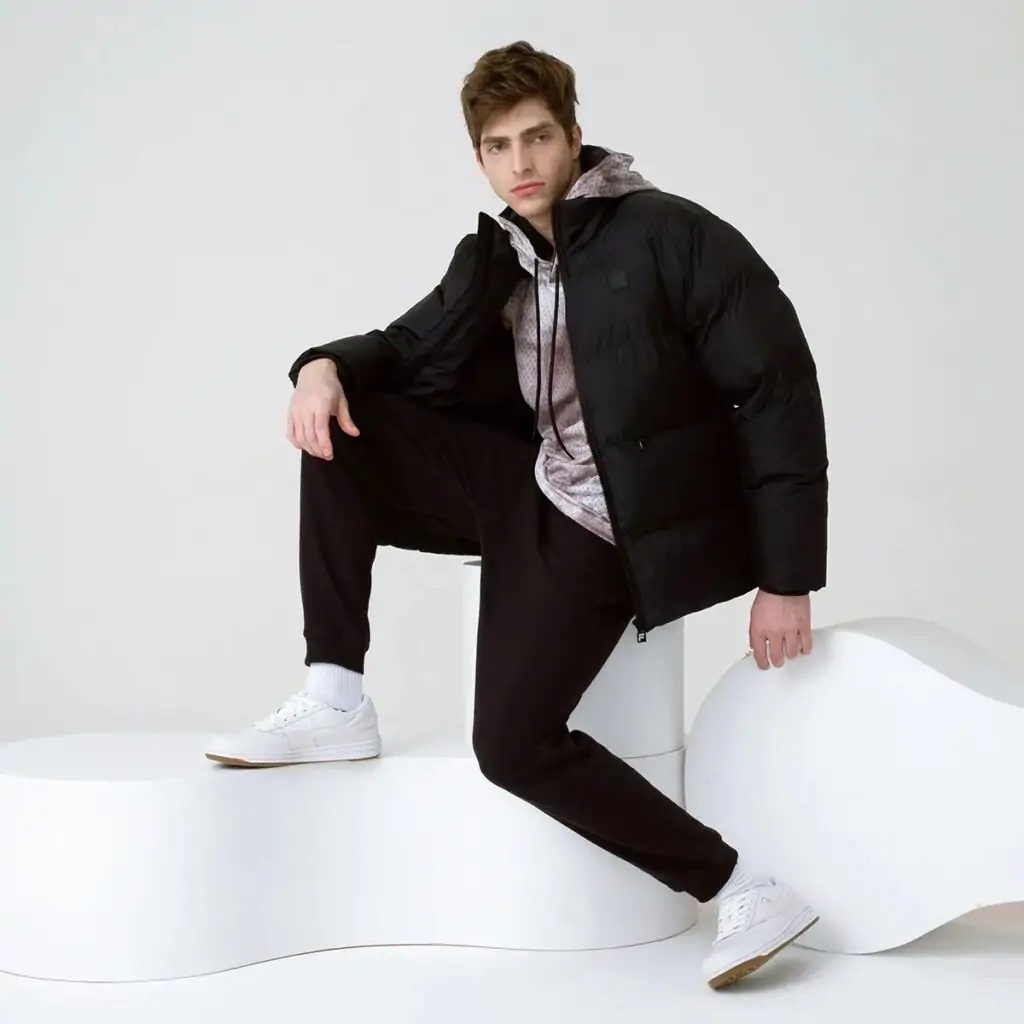 A Jaqueta Masculina Fila Round é a escolha ideal para os dias mais frios. Confeccionada em matelassê de poliéster com modelagem puffer, oferece isolamento térmico e conforto inigualável.