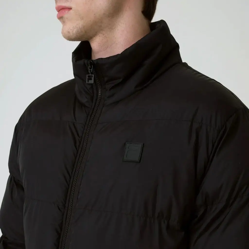 A Jaqueta Masculina Fila Round é a escolha ideal para os dias mais frios. Confeccionada em matelassê de poliéster com modelagem puffer, oferece isolamento térmico e conforto inigualável.