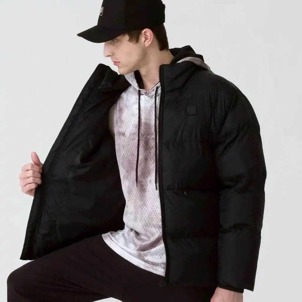 A Jaqueta Masculina Fila Round é a escolha ideal para os dias mais frios. Confeccionada em matelassê de poliéster com modelagem puffer, oferece isolamento térmico e conforto inigualável.